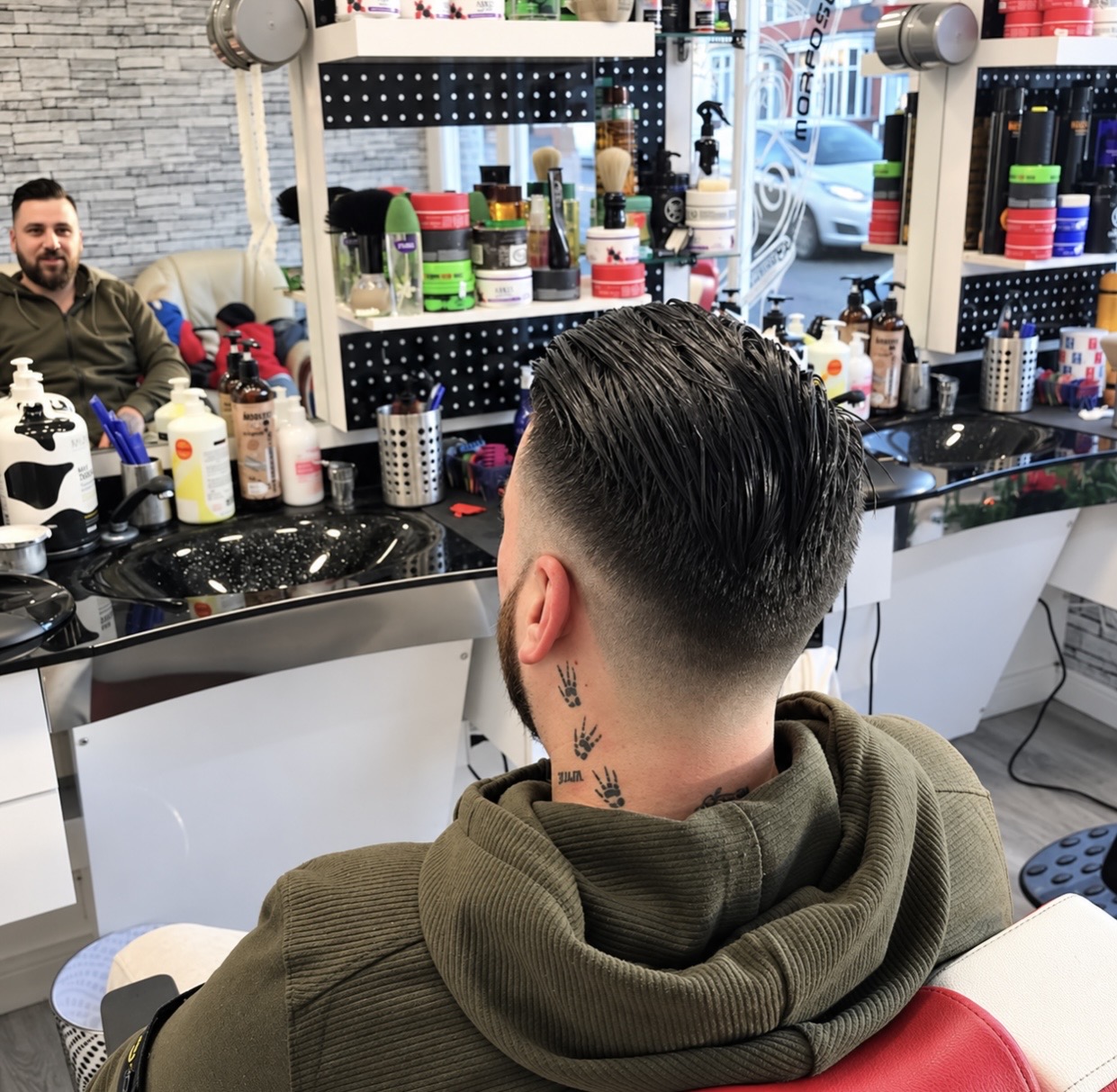 Customer in a green hoodie showing a clean finished fade